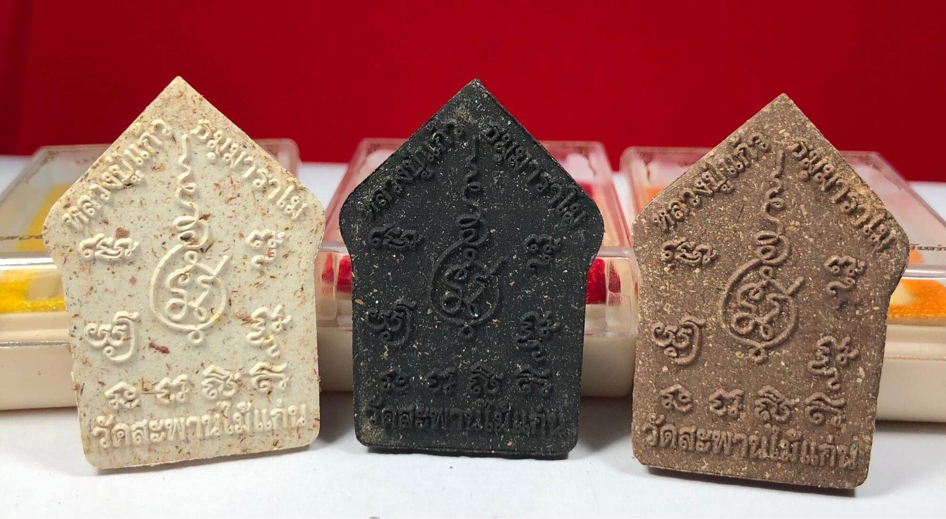 Three Phra Khun Paen Amulet - Blessed by Luang Pu Kaew, Wat Sapan Mai Kaen. Cream black and brown amulets with carved Thai script