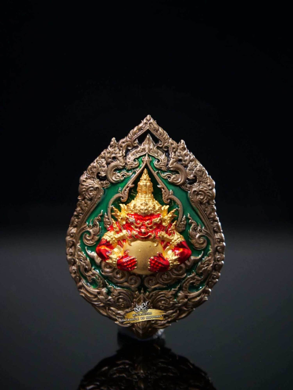 Ornate Thai amulet medallion with gold and red Garuda holding deity figure on green enamel Narayana on Garuda Medallion