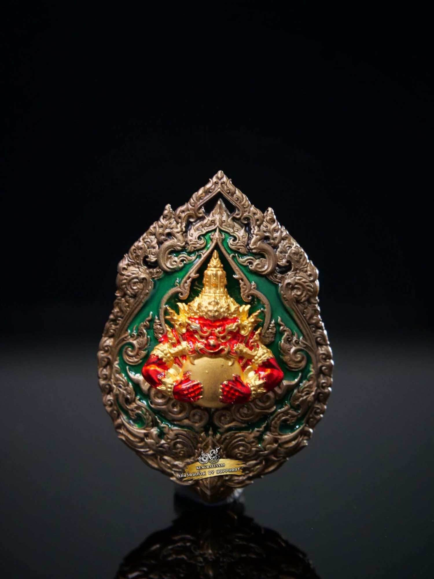 Ornate Thai amulet medallion with gold and red Garuda holding deity figure on green enamel Narayana on Garuda Medallion
