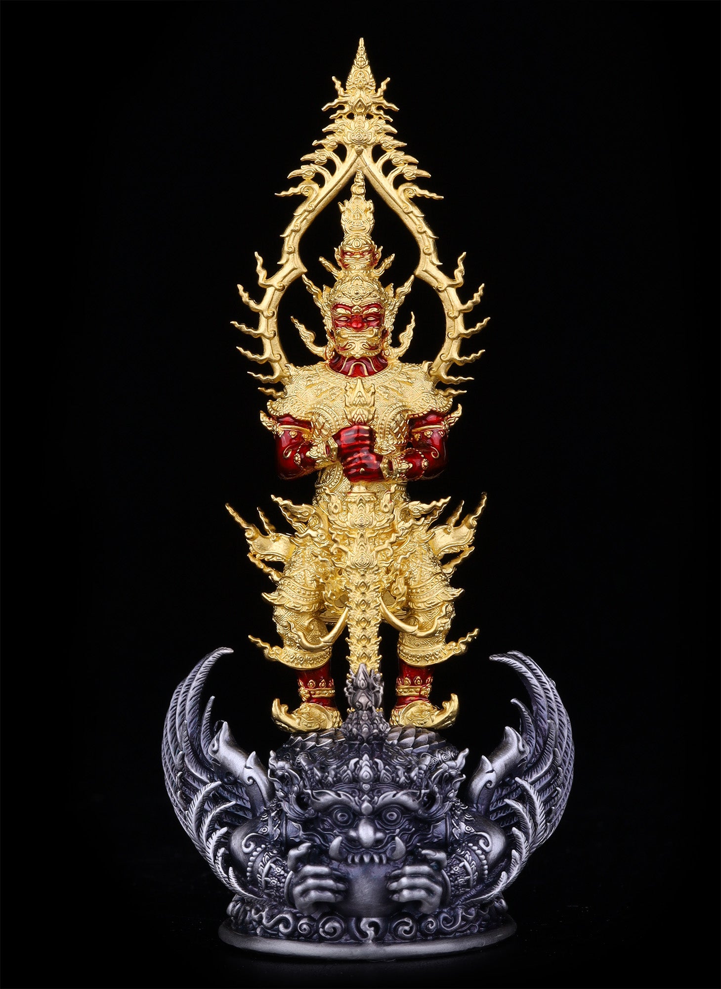 Gold and red Thao Wessuwan statue for wealth and protection. Ornate standing amulet on silver guardian base