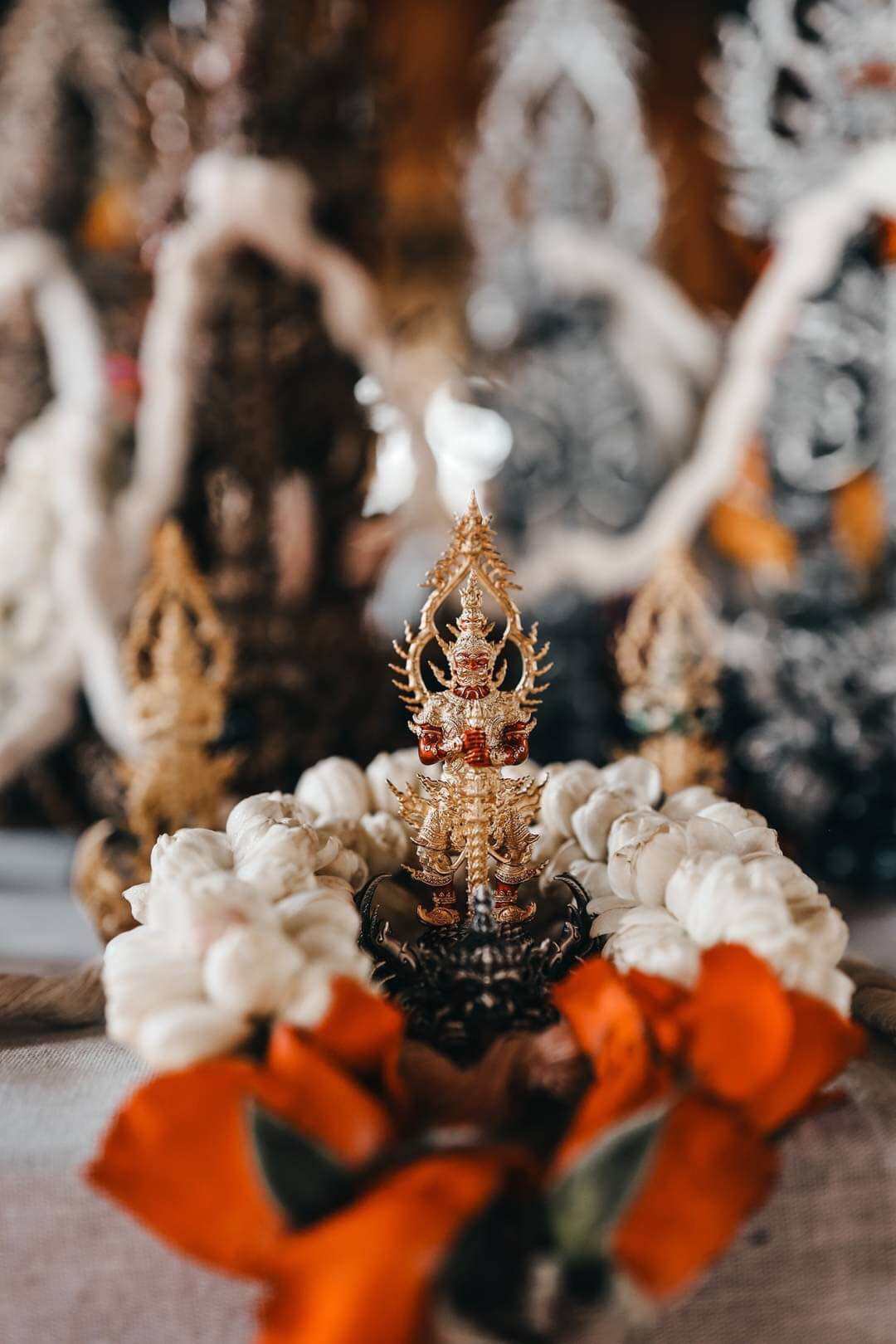 Thai Blessing Co Thao Wessuwan statue for wealth and protection. Gold amulet pendant on jasmine garland