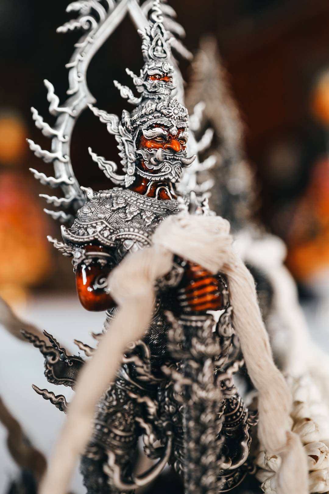 Silver Thai guardian pendant Thao Wessuwan statue for wealth and protection. Ornate embossed amulet with red lacquer accents