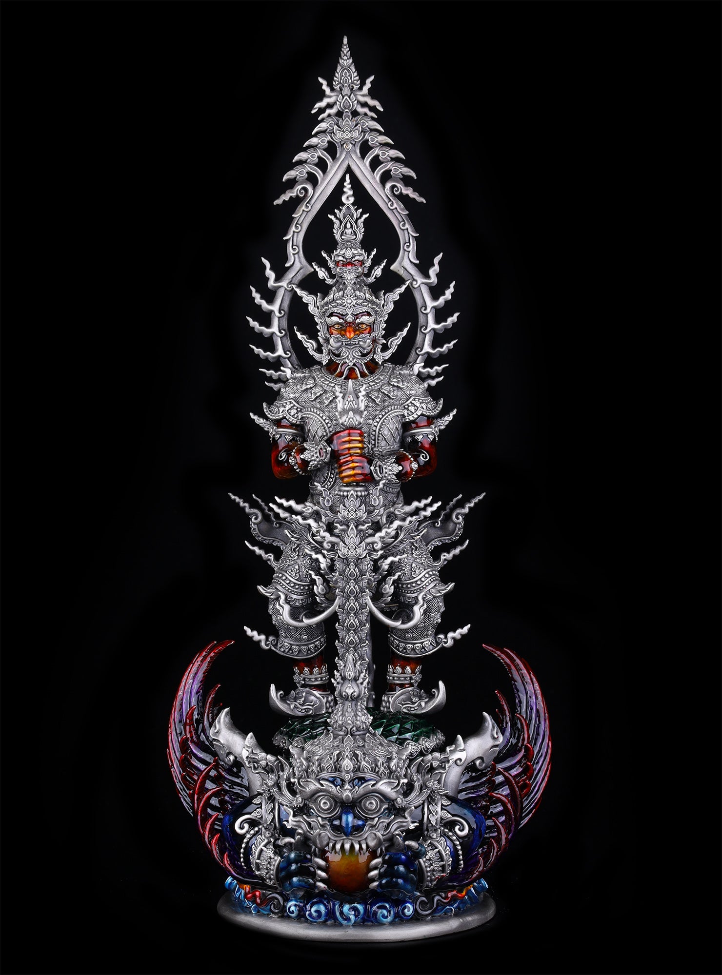 Thao Wessuwan statue for wealth and protection. Ornate silver Thai pendant statue with red eyes and blue gem base