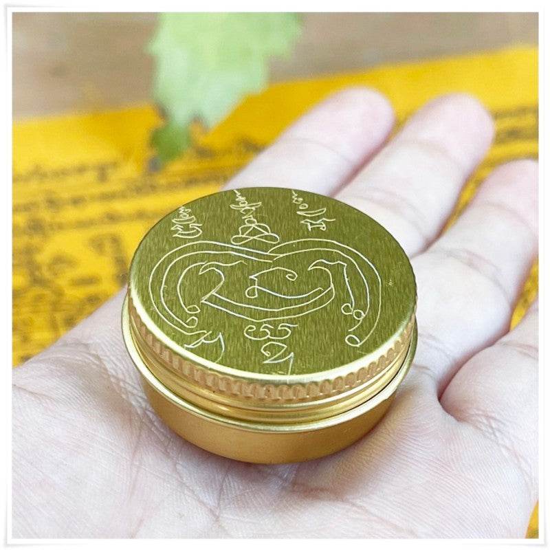 Thai beeswax balm for pain relief in a gold tin can, perfect for soothing sore muscles