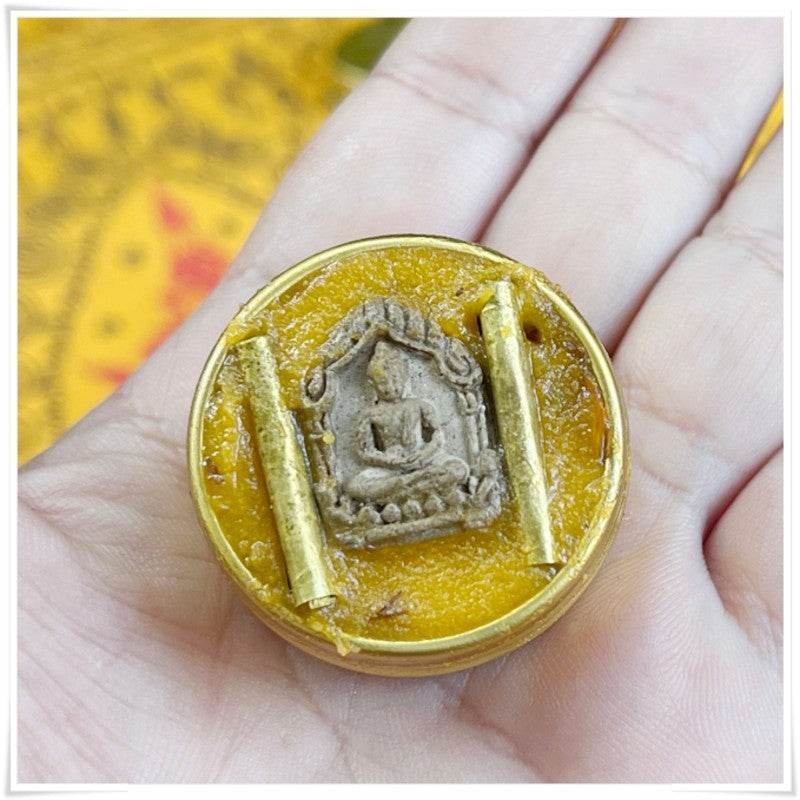 Thai beeswax balm for pain relief in a small round container with a decorative design