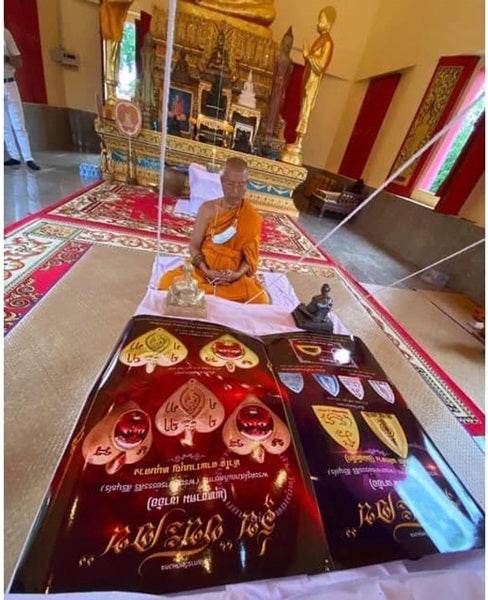 Thai blessed talisman good luck displayed with a monk in a traditional temple setting