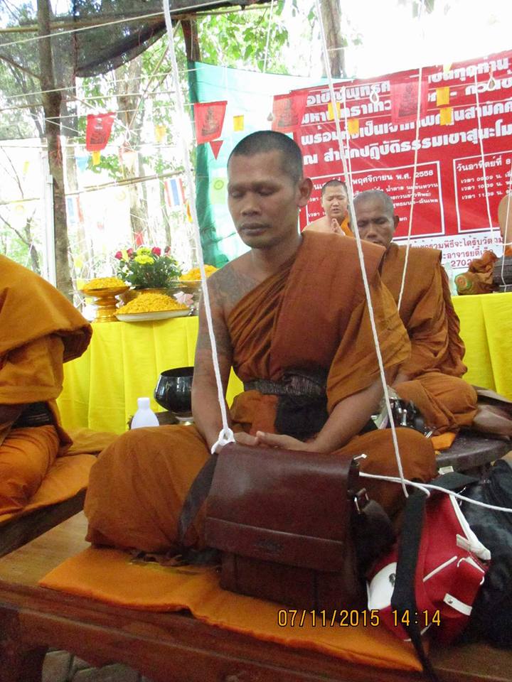 Phra Ajarn Tee Lek sacred locket displayed with Thai monks during a ceremonial event