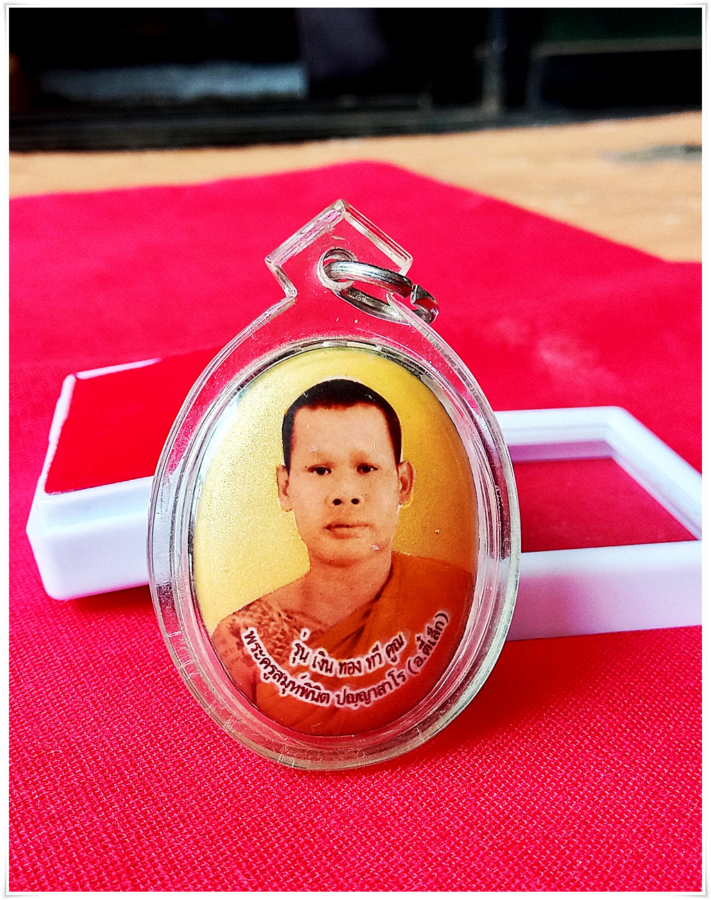 Phra Ajarn Tee Lek sacred locket featuring a monk's image encased in a clear protective frame