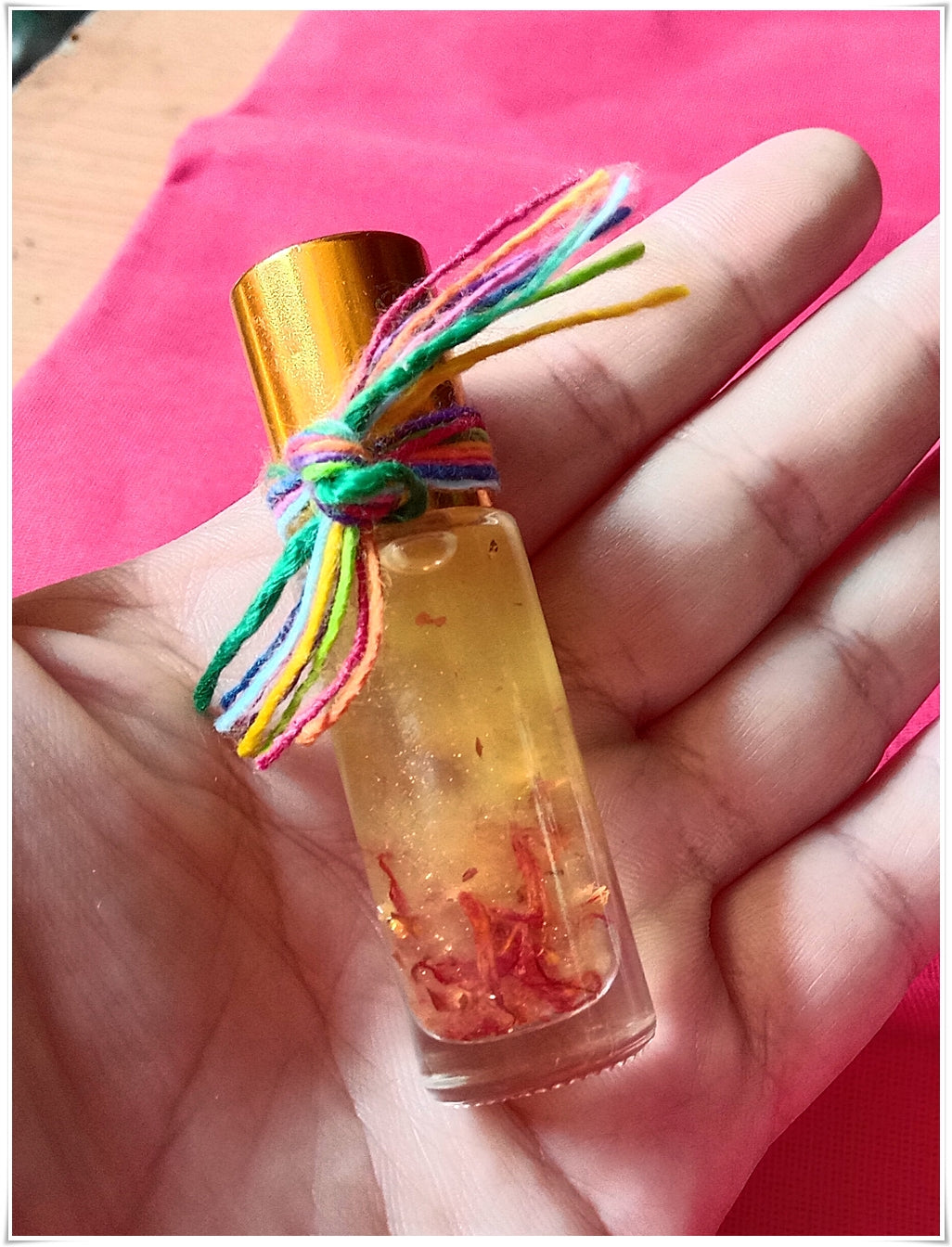 Thai Blessing Co small glass roll on bottle with red petals and colorful yarn tie thai buddhist fortune oil