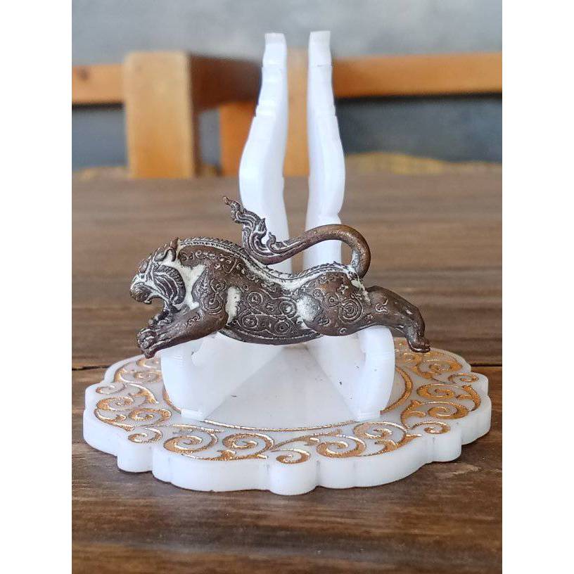 Tiger Pern amulet for protection metal tiger figurine on white carved stand with gold details
