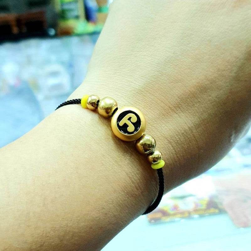 Namo Maha Mongkol Bracelet with Phra Pidta Amulet black cord bracelet with gold beads and central amulet on wrist