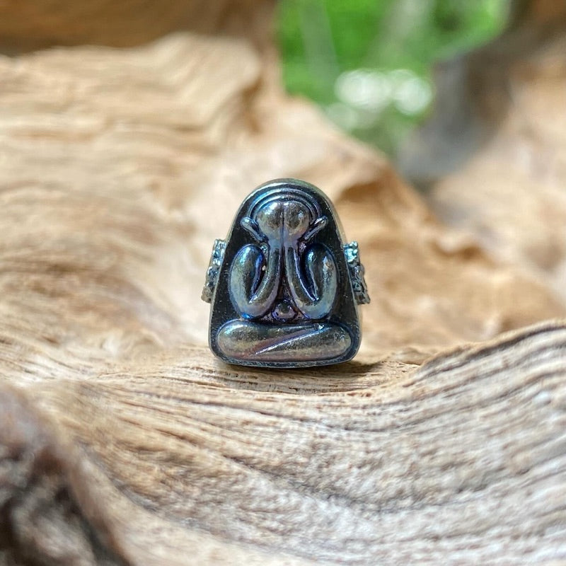Blue tone Thai Buddhist amulet with intricate design sitting on textured wood surface
