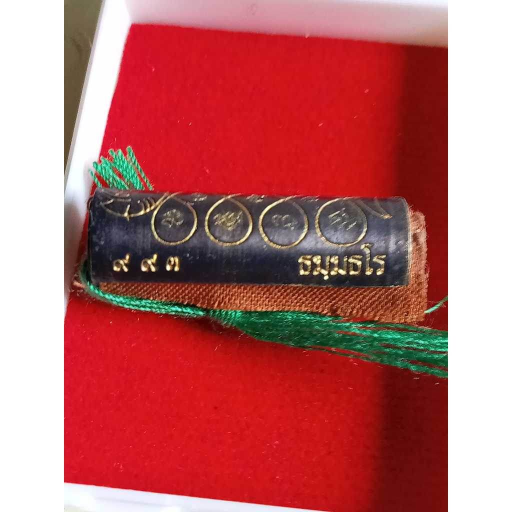 Thai boar talisman for luck with black and gold inscriptions and green tassel in red box