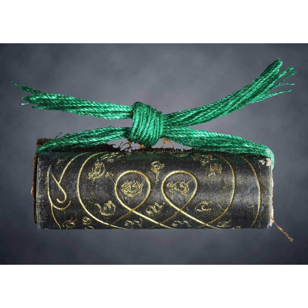 Thai boar talisman for luck with intricate gold script and green cord from Thai Blessing Co