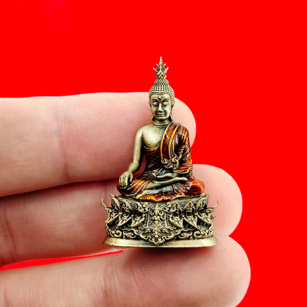 Miniature Thai Buddha amulet blessed by Luang Por Weera, finely detailed and held in hand for scale