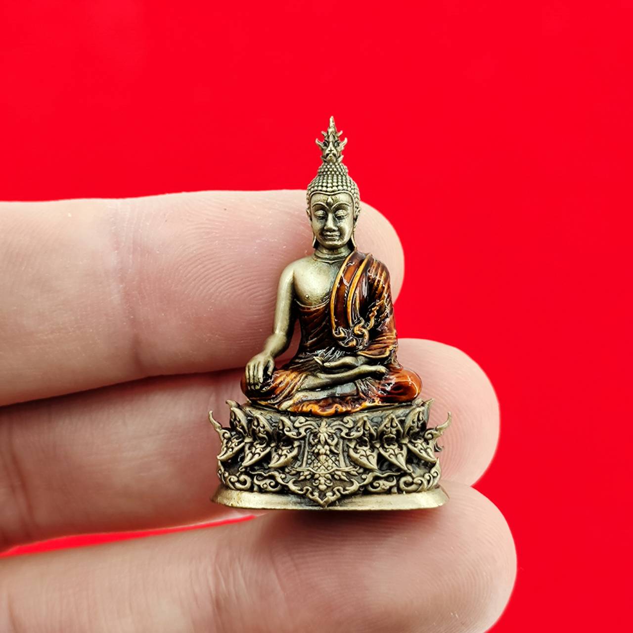 Miniature Thai Buddha amulet blessed by Luang Por Weera, finely detailed and held in hand for scale