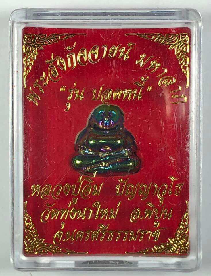 Thai Buddha debt release amulet in clear protective case with red and gold decorative background