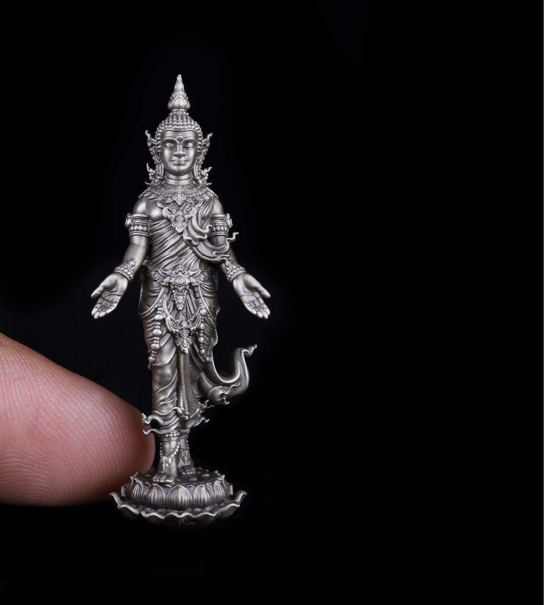 Thai Buddhist lucky charm pendant featuring a finely detailed silver deity statue held by a finger