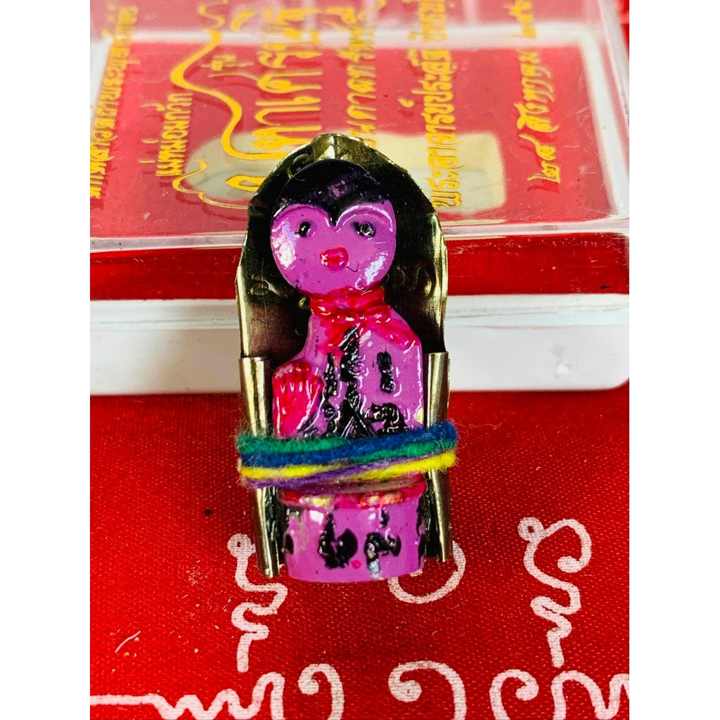 Thai business prosperity amulet featuring colorful figure wrapped with vibrant thread on red background