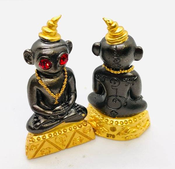 Thai charm amulet for luck featuring a black figurine with red eyes and a golden crown