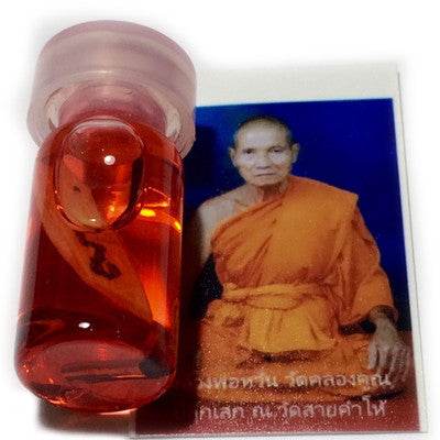 Thai charm oil for luck and popularity with an image of a monk on the packaging