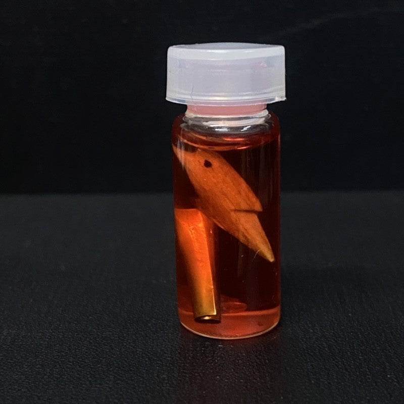 Thai charm oil for luck and popularity in a glass vial with herbal ingredients for good fortune
