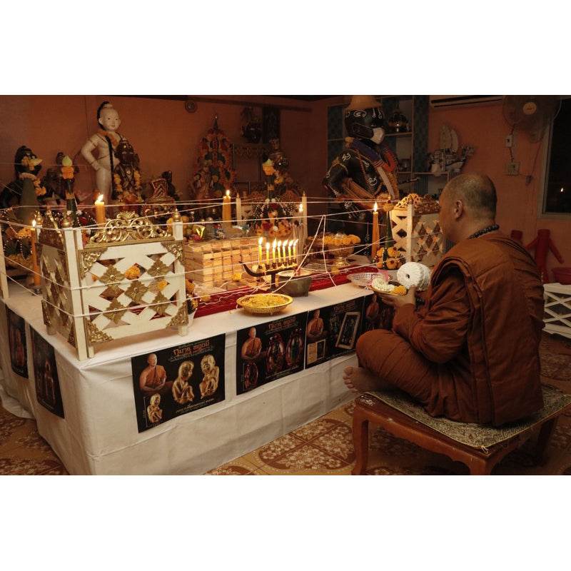 Thai child spirit for good luck displayed during a traditional blessing ceremony with candles and offerings