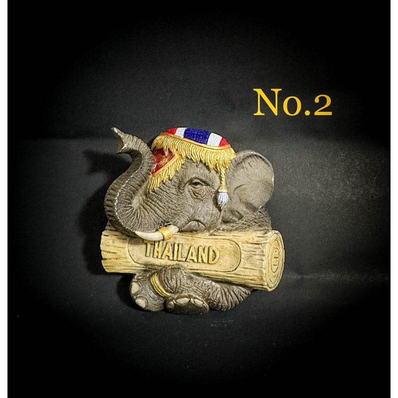 Thai elephant fridge magnet holding a Thailand log with traditional decorative cloth on its head
