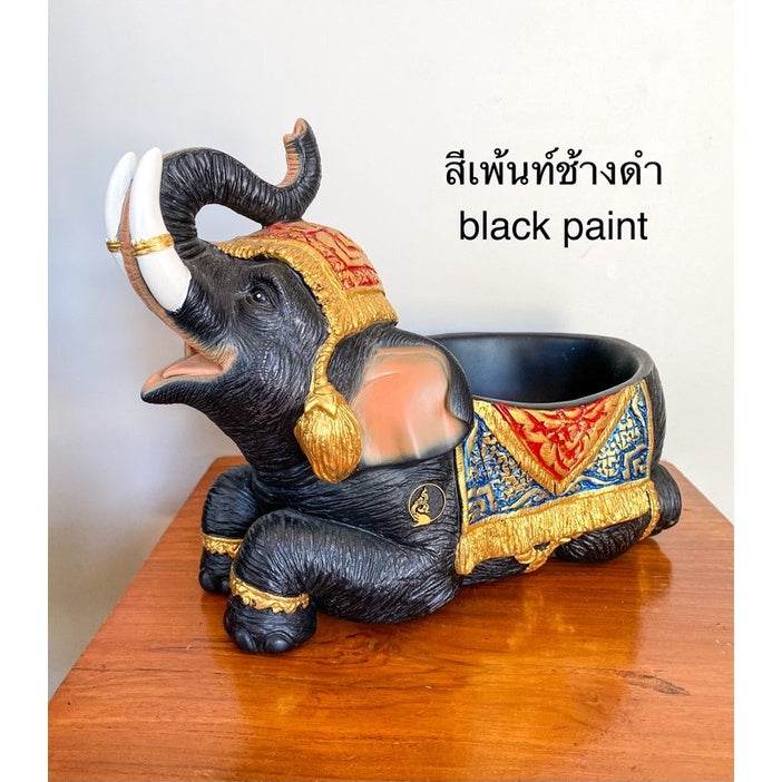 Black painted Thai elephant resin tray with intricate gold and red detailing on wooden table