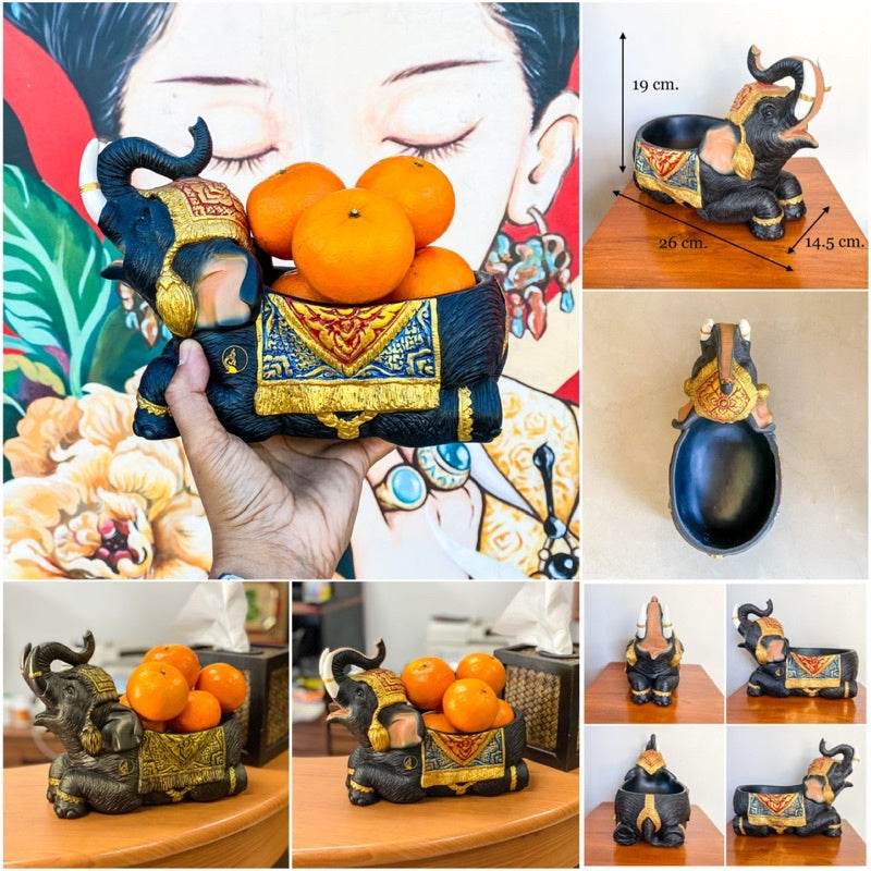 Handcrafted Thai elephant resin tray with intricate gold and black detailing holding oranges on wooden table