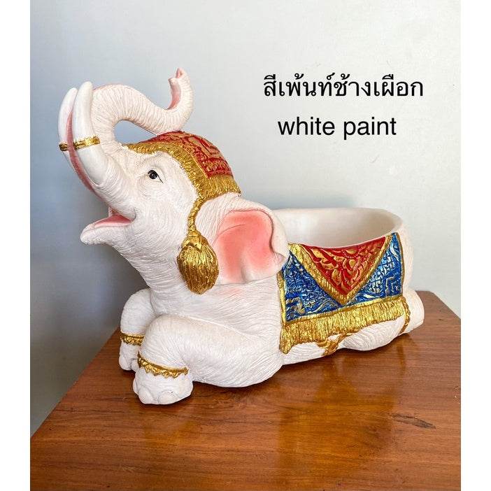 White paint Thai elephant resin tray with red blue and gold decorative accents on wooden table