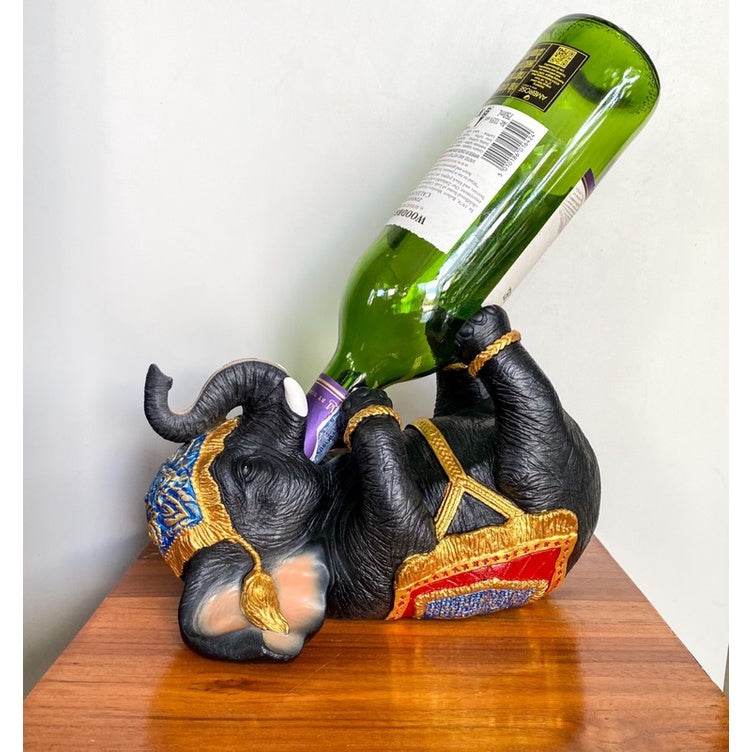 Thai elephant wine rack holding a green wine bottle on a wooden table from One-Sake.com