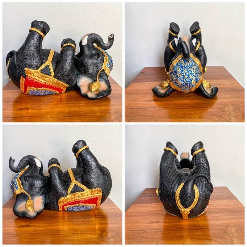 Decorative Thai elephant wine rack with intricate gold and blue detailing on wooden table