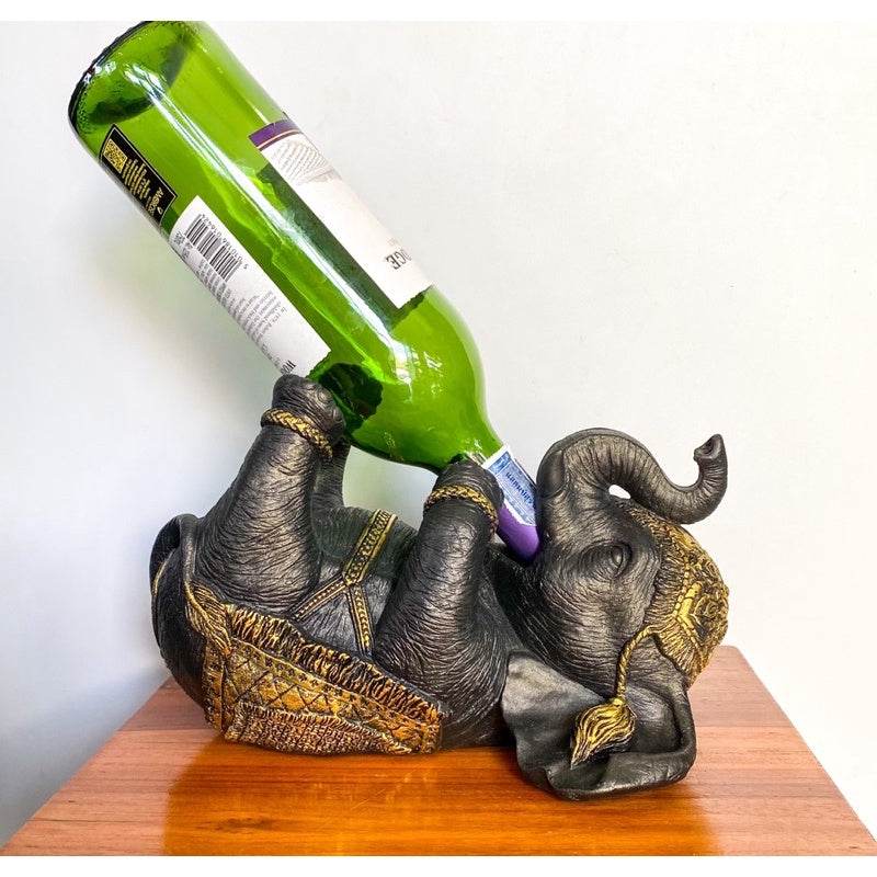 Thai elephant wine rack holding a green wine bottle on wooden surface by One-Sake.com
