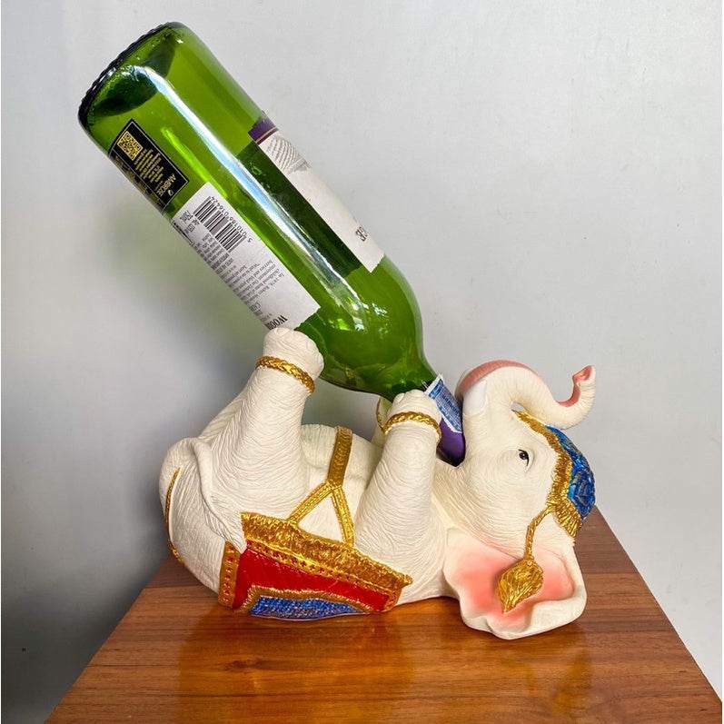 Thai elephant wine rack holding a green wine bottle with colorful gold and blue accents
