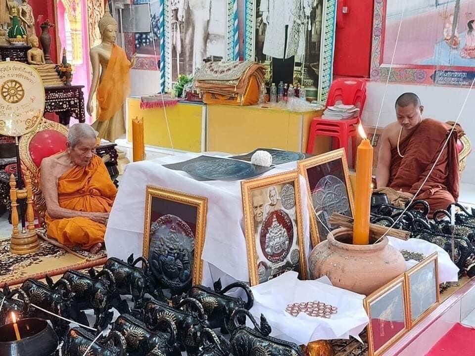 First Edition Rahu Amulet display with framed amulets and Buddhist monks at temple altar