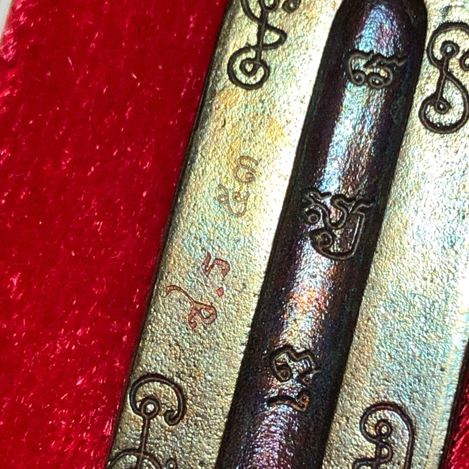 First edition Thao Wessuwan medal close up showing engraved Thai script on bronze metal with red velvet