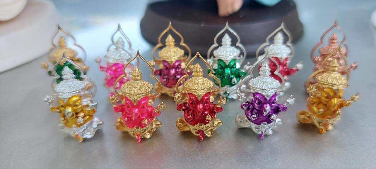 Colorful Thai Ganesha amulet for wealth displayed in various hues with intricate detailing