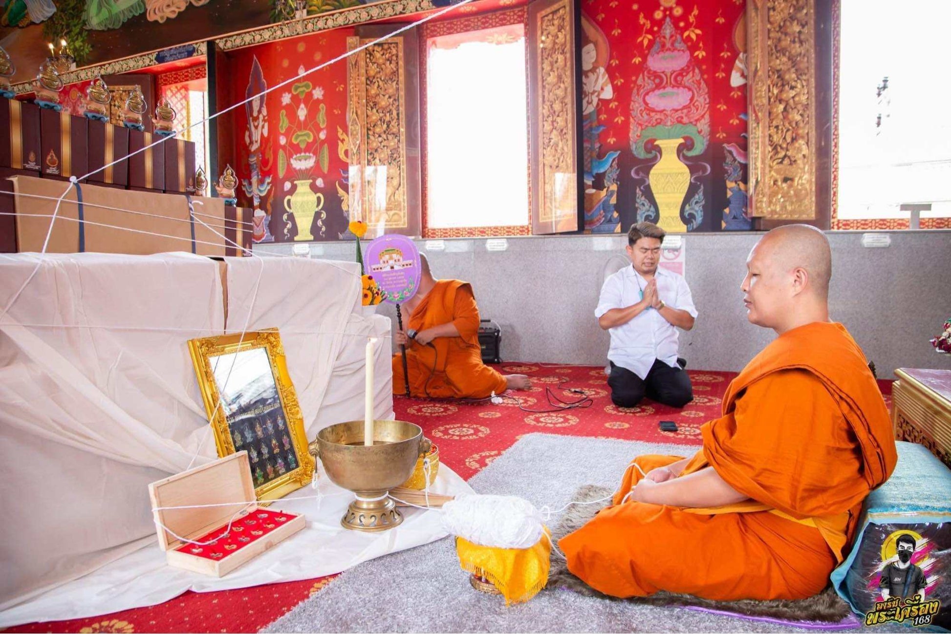 Buddhist monk performing rituals with Thai Ganesha amulet for wealth on an altar