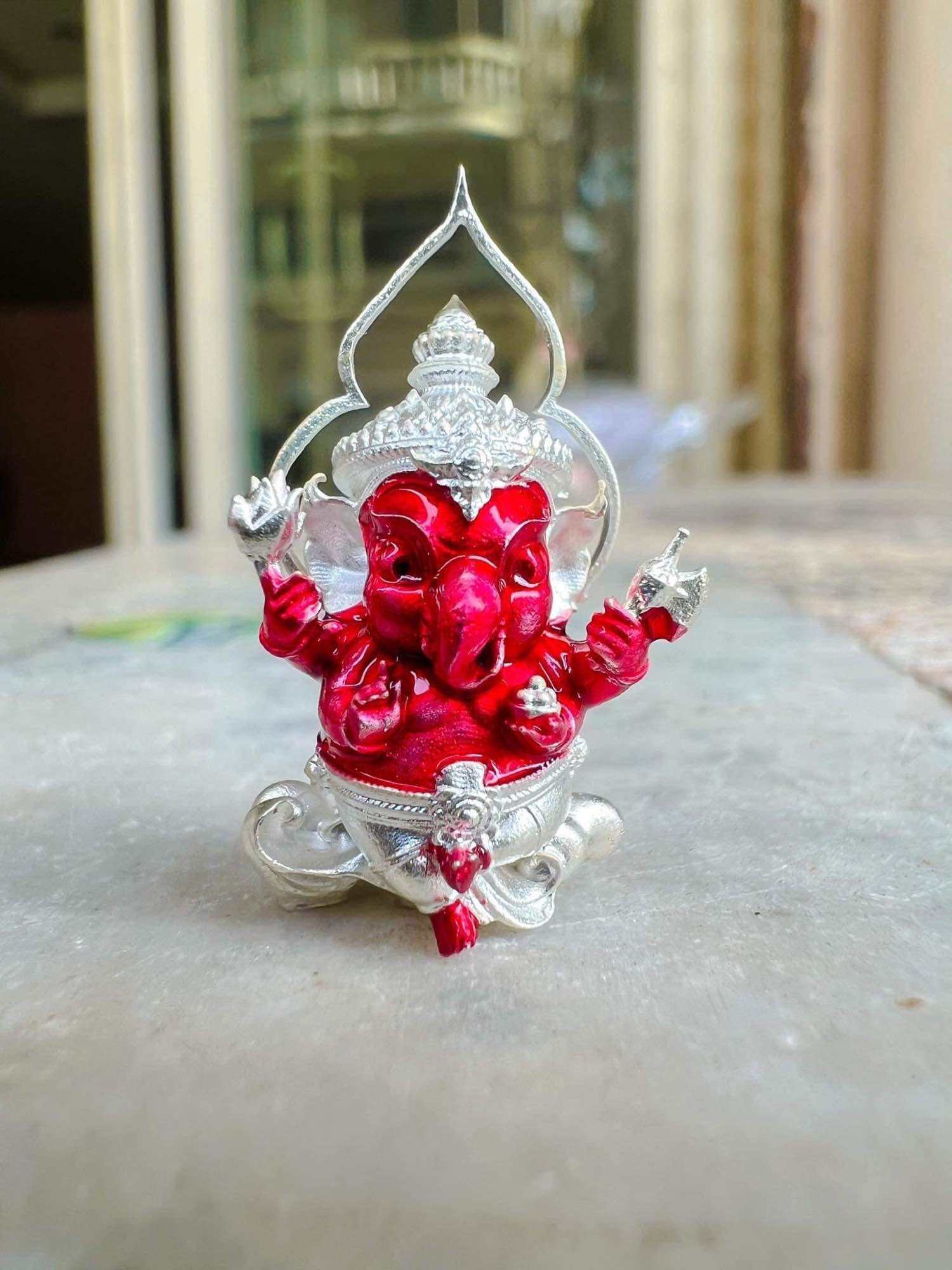 Thai Ganesha amulet for wealth in red and silver, designed to attract prosperity and good fortune