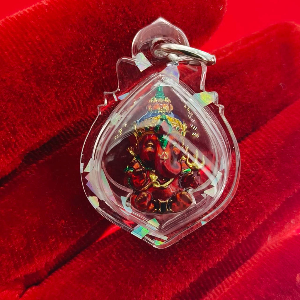 Thai Ganesha lucky charm pendant in a clear protective casing, featuring intricate details of Ganesha