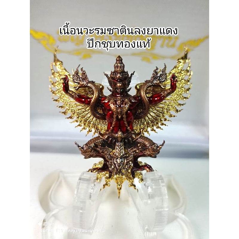 Thai Garuda lucky charm with red body and gold wings displayed on a clear stand