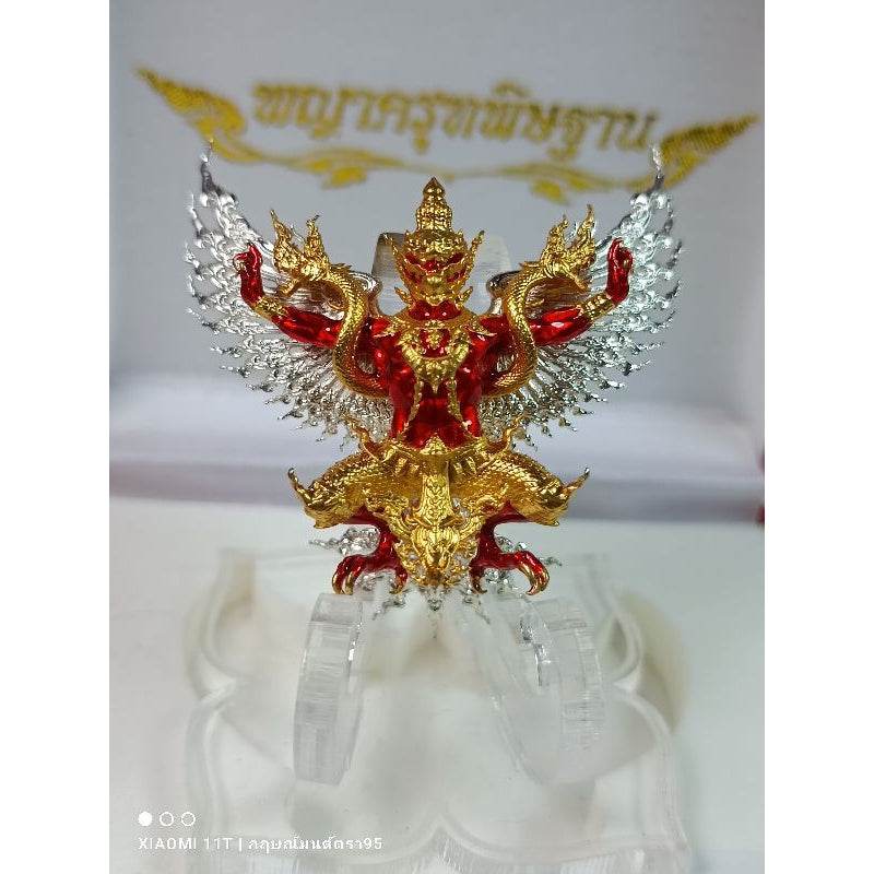 Thai Garuda lucky charm with red gold and silver detailing displayed on clear stand