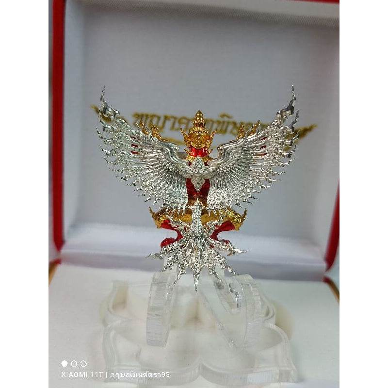 Thai Garuda lucky charm silver and gold statue with red accents displayed in a white and red box