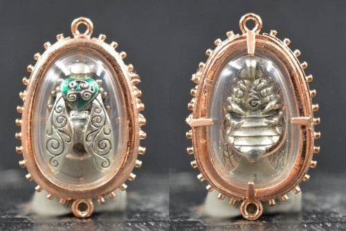 Thai golden bee amulet for wealth encased in clear oval resin with intricate metal frame