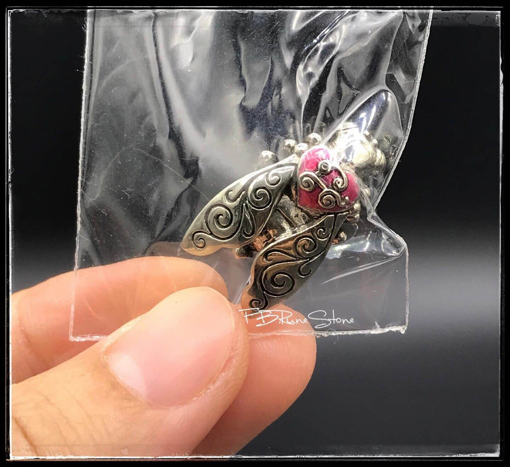 Thai golden bee amulet for wealth held in hand in clear plastic packaging by Thai Blessing Co