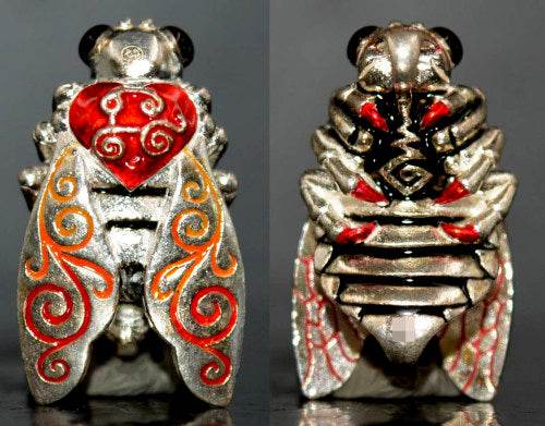 Thai golden bee amulet for wealth with intricate red and orange patterns and detailed silver body