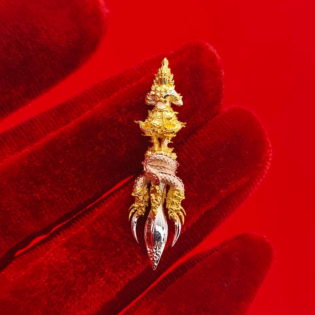 Thai guardian amulet Klang Setthi edition with intricate gold and silver detailing displayed on a hand
