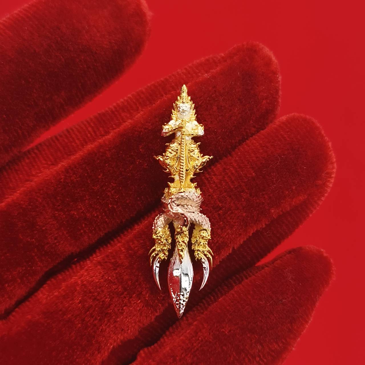 Thai guardian amulet Klang Setthi edition featuring intricate gold and silver detailing on a red background