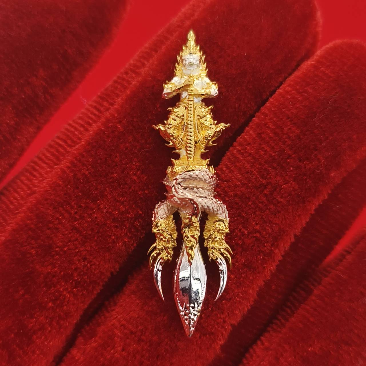 Thai guardian amulet Klang Setthi edition featuring intricate gold and silver design on a red velvet background